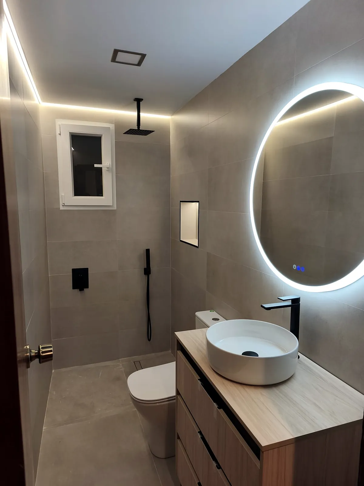 Baño reformado con espejo iluminado